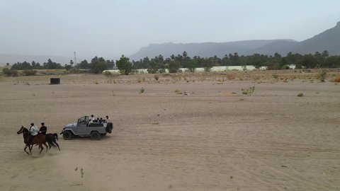 The hobby of riding purebred Arabian horses, an exciting safari adventure on the sand dunes and hills, a fun recreational activity, safari trips in the deserts of the Kingdom of Saudi Arabia, spending a special trip in the desert environment, driving an old white jeep in the Najran Valley, (drifting) in the middle of the desert