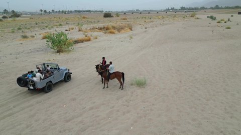 The hobby of riding purebred Arabian horses, an exciting safari adventure on the sand dunes and hills, a fun recreational activity, safari trips in the deserts of the Kingdom of Saudi Arabia, spending a special trip in the desert environment, driving an old white jeep in the Najran Valley, (drifting) in the middle of the desert