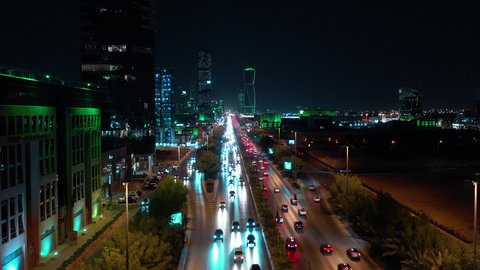  حركة وسائل النقل والمواصلات في الشوارع والطرقات الرئيسية في المملكة العربية السعودية، تصوير درون جوي للحركة المرورية المنظمة للسيارات في العاصمة، نمو وتطور البنية التحتية، ابراج مضاءة باللون الاخضر للاحتفال باليوم الوطني السعودي  في الرياض