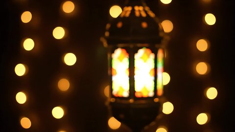 اكسسوارات و تحف تقليدية للاحتفال بقدوم شهر الخير، تصوير مقرب لفانوس معدني مزخرف مضيء، زينة و إضاءة رمضان المبارك، الأنوار والمصابيح في الأجواء الرمضانية الروحانية، الشعور بالسكينة والراحة