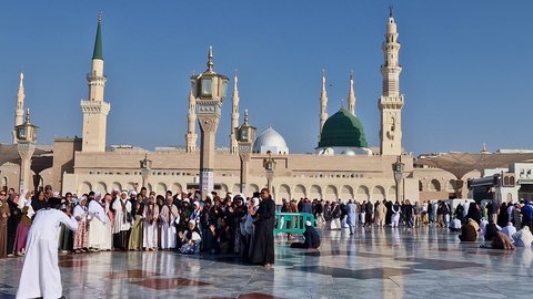 The outer courtyard of the Prophet's Mosque in Medina, Saudi Arabia, the architectural art of the minarets and the green dome, Islamic holy places, a sacred religious landmark during the day