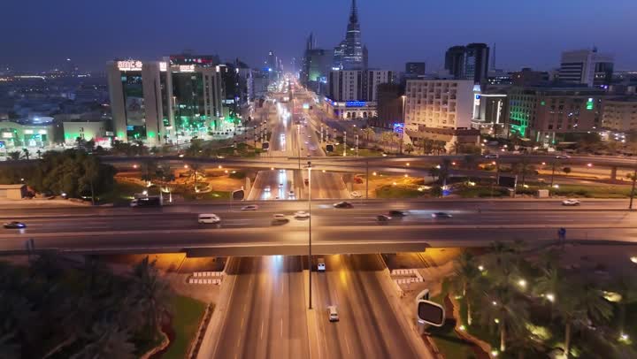 The economic and urban renaissance of the capital's skyline, the movement of transportation and communication means on the streets and main roads in the Kingdom of Saudi Arabia, aerial drone photography of organized traffic movement of cars, the growth and development of infrastructure