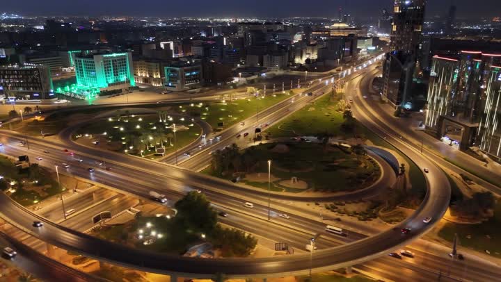 The economic and urban renaissance of the capital's skyline, the movement of transportation and communication means on the streets and main roads in the Kingdom of Saudi Arabia, aerial drone photography of organized traffic movement of cars, the growth and development of infrastructure