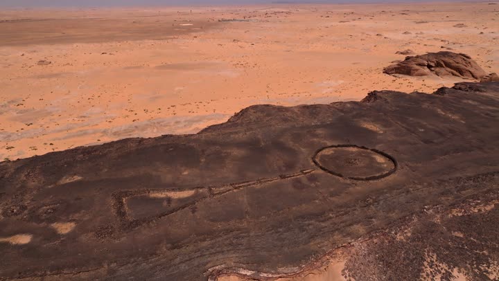 Historical archaeological landmarks, a crater in the city of Hail in the Kingdom of Saudi Arabia, a deep volcanic hole in the ground, the white salt layer collected at the bottom of the crater, mountains and rocky heights, natural geological phenomena