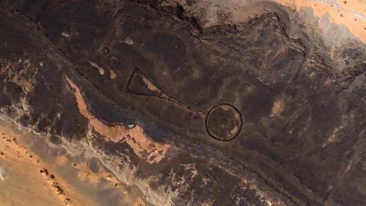 Historical archaeological landmarks, a crater in the city of Hail in the Kingdom of Saudi Arabia, a deep volcanic hole in the ground, the white salt layer collected at the bottom of the crater, mountains and rocky heights, natural geological phenomena