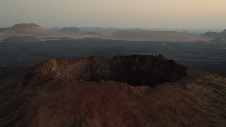 Historical archaeological landmarks, a crater in the city of Hail in the Kingdom of Saudi Arabia, a deep volcanic hole in the ground, the white salt layer collected at the bottom of the crater, mountains and rocky heights, natural geological phenomena