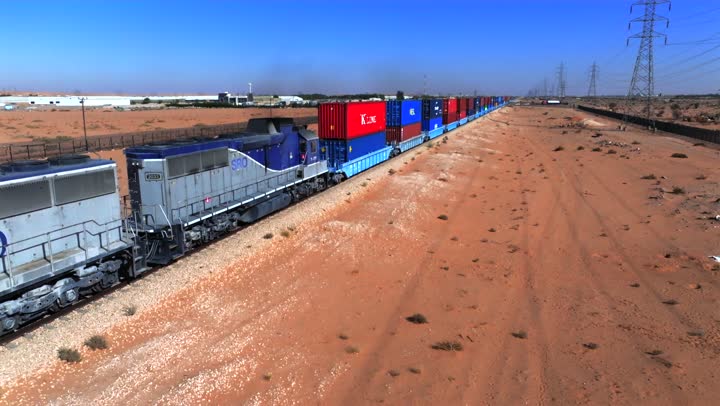 Export and import of goods in the Kingdom of Saudi Arabia, the economy of transporting and receiving storage containers, shipping goods and commercial containers, delivering goods and local products by freight train, soft golden sands in the desert