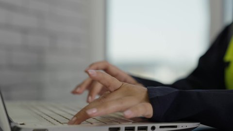 مهارة الكتابة السريعة على لوحة المفاتيح ،مفهوم الهندسة والإنشاءات المعمارية، تصوير مقرب  لأيدي مهندسة عربية خليجية سعودية ترتدي سترة الوقاية تقوم بالعمل عبر جهاز الحاسوب، مهن ووظائف مكتبية نسائية، استخدام الأجهزة التقنية الحديثة