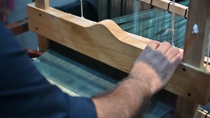 صناعة المشالح باستخدام الخيوط الملونة، الشغف في ممارسة مهنة الغزل و النسج, تصوير مقرب لرجل عربي خليجي سعودي يقوم بحياكة وغزل الانسجة والقماش, حرفة يدوية تاريخيه, المحافظة على التراث الشعبي السعودي