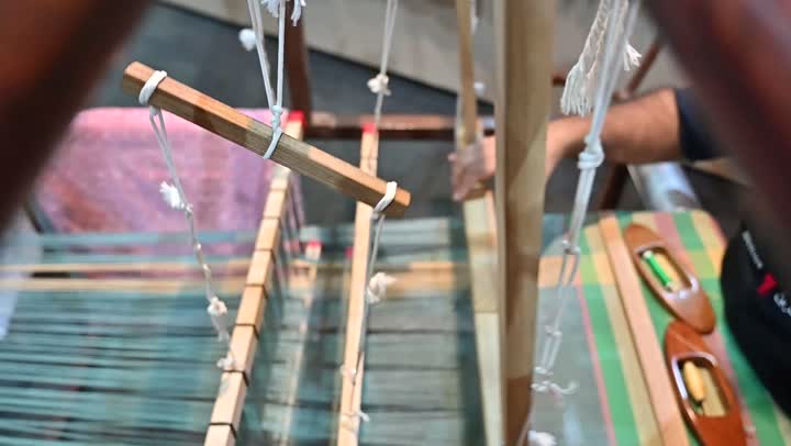 صناعة المشالح باستخدام الخيوط الملونة، الشغف في ممارسة مهنة الغزل و النسج, تصوير مقرب لرجل عربي خليجي سعودي يقوم بحياكة وغزل الانسجة والقماش, حرفة يدوية تاريخيه, المحافظة على التراث الشعبي السعودي