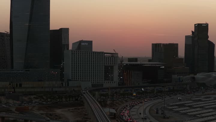 النهضة الاقتصادية والعمرانية, تصوير درون جوي لأفق مدينة الرياض وقت غروب الشمس, الأبراج وناطحات السحاب على الطراز الحديث والمتطور, معالم التجارة والاقتصاد المشهورة في العاصمة السعودية، مركز الملك عبد الله المالي (كافد) المضاء