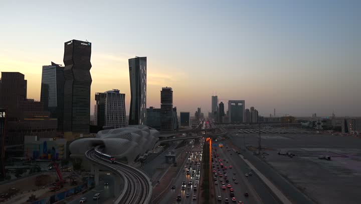 النهضة الاقتصادية والعمرانية, تصوير درون جوي لأفق مدينة الرياض وقت غروب الشمس, الأبراج وناطحات السحاب على الطراز الحديث والمتطور, معالم التجارة والاقتصاد المشهورة في العاصمة السعودية، مركز الملك عبد الله المالي (كافد) المضاء