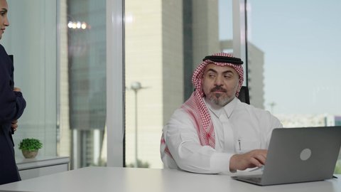 اجراء اجتماع لفريق عمل عربي خليجي سعودي داخل مقر الشركة، تطوير ودراسة وتحليل المشاريع الجديدة، الوحدة والعمل الجماعي، استخدام جهاز تقني حديث، موظفة تقوم بتقديم المشاريع للمدير لتدقيقها، مهنة ووظيفة سعودية مكتبية