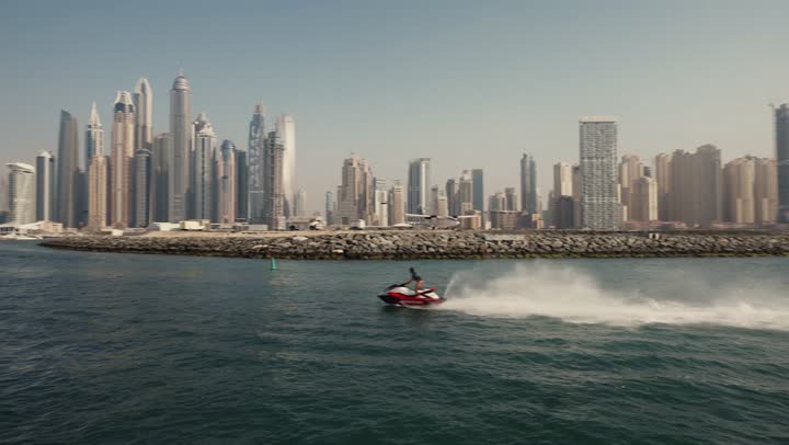 Sailing in the harbor and yacht marina in Dubai Marina, the architectural art of the buildings and structures overlooking the sea, the urban growth of towers and skyscrapers in the United Arab Emirates, famous tourist attractions in Dubai, the waterfront overlooking the Arabian Gulf coast