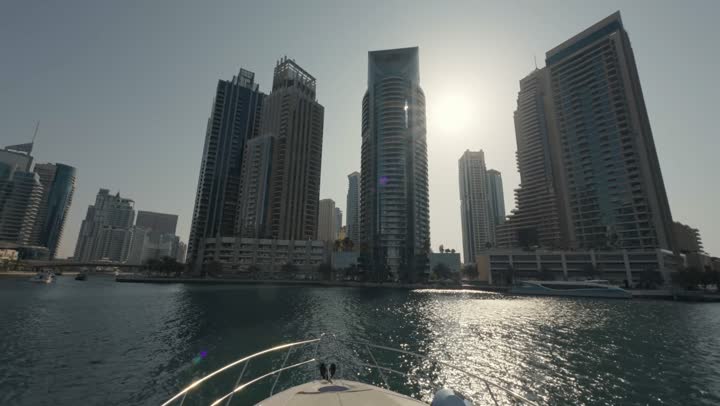 Sailing in the harbor and yacht marina in Dubai Marina, the architectural art of the buildings and structures overlooking the sea, the urban growth of towers and skyscrapers in the United Arab Emirates, famous tourist attractions in Dubai, the waterfront overlooking the Arabian Gulf coast