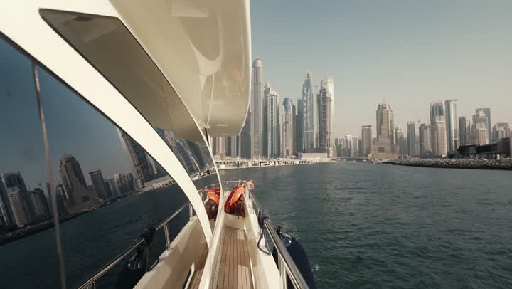 The waterfront overlooking the Arabian Gulf, sailing in the harbor and yacht marina in Dubai Marina, the architectural art of the buildings and structures overlooking the sea, the progress and urban growth of towers and skyscrapers in the United Arab Emirates, and the famous tourist attractions in Dubai