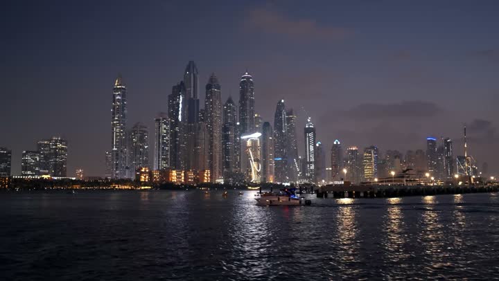 The waterfront overlooking the Arabian Gulf, sailing in the harbor and yacht marina in Dubai Marina, the architectural art of the buildings and structures overlooking the sea, the progress and urban growth of towers and skyscrapers in the United Arab Emirates, and the famous tourist attractions in Dubai