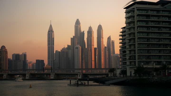 The waterfront overlooking the Arabian Gulf, sailing in the harbor and yacht marina in Dubai Marina, the architectural art of the buildings and structures overlooking the sea, the progress and urban growth of towers and skyscrapers in the United Arab Emirates, and the famous tourist attractions in Dubai