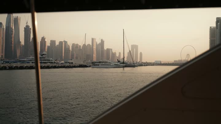 The urban growth of towers and skyscrapers in the United Arab Emirates, famous tourist attractions in Dubai, the waterfront overlooking the Arabian Gulf coast, sailing in the harbor and yacht marina in Dubai Marina, the architectural art of buildings and structures overlooking the sea