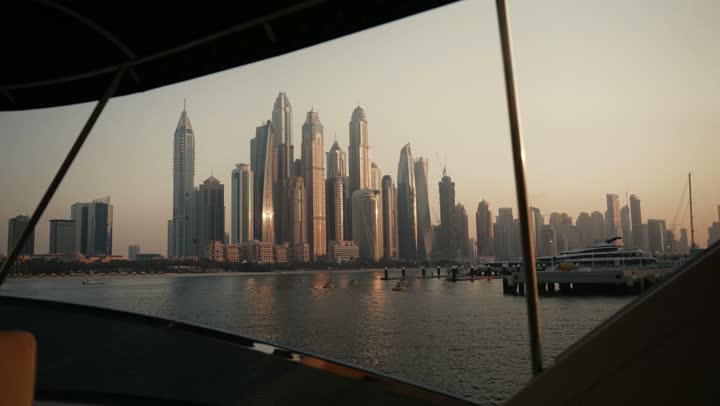 The urban growth of towers and skyscrapers in the United Arab Emirates, famous tourist attractions in Dubai, the waterfront overlooking the Arabian Gulf coast, sailing in the harbor and yacht marina in Dubai Marina, the architectural art of buildings and structures overlooking the sea