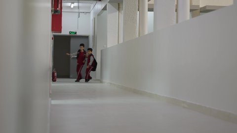 Preparing for the new school semester, Arab Saudi Gulf students running in the school hallway, play and recreation time, the school break, gestures indicating happiness and fun, academic schools in the Kingdom of Saudi Arabia.
