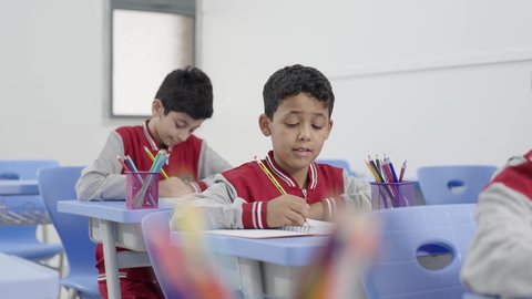 Preparation for the new school year, completing homework, education in Saudi Arabia, back to school, a group of Arab Gulf Saudi students sitting in their seats and doing their homework.