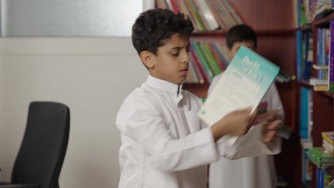 التعليم في المملكة العربية السعودية، طلاب عربيين سعوديين خليجيين في المكتبة المدرسية، الاستمتاع بقراءة الكتب المدرسية، تأدية الواجبات المدرسية