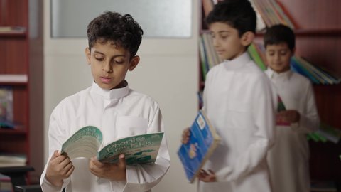 تأدية الواجبات المدرسية، طلاب عربيين سعوديين خليجيين في المكتبة المدرسية، الاستمتاع بقراءة الكتب المدرسية، التعليم في المملكة العربية السعودية