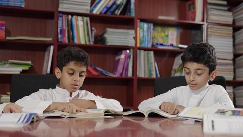 Spending enjoyable time, friendly dialogues between the teacher and the student, Arab Saudi Gulf students in the school library, enjoying reading school books, doing homework, education in the Kingdom of Saudi Arabia.