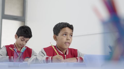 جودة التعليم في السعودية، معلم عربي خليجي سعودي يرتدي الثوب التقليدي والشماغ يقوم بمناقشة الدروس مع طلابه، المشاركة الفعالة للطلاب مع المدرسين، التربية والتعليم بالمناهج المقررة للتلاميذ، حوارات ودية بين الاستاذ والطلاب