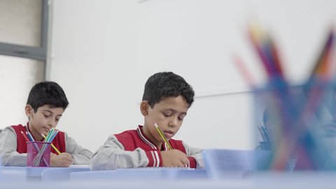 المشاركة الفعالة للطلاب مع المدرسين، معلم عربي خليجي سعودي يرتدي الثوب التقليدي والشماغ يقوم بمناقشة الدروس مع طلابه، جودة التعليم في السعودية، التربية والتعليم بالمناهج المقررة للتلاميذ، حوارات ودية بين الاستاذ والطلاب