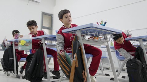 Preparation for the new school year, completing homework, education in Saudi Arabia, back to school, a group of Arab Gulf Saudi students sitting at their desks and doing their homework.