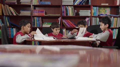 تأدية الواجبات المدرسية، طلاب عربيين سعوديين خليجيين في المكتبة المدرسية، الاستمتاع بقراءة الكتب المدرسية، التعليم في المملكة العربية السعودية