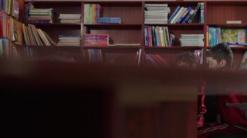 Enjoying reading school books, Arab Saudi Gulf students in the school library, doing homework, education in the Kingdom of Saudi Arabia.