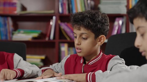 Saudi Arabian Gulf Arab students in the school library, enjoying reading textbooks, doing homework, education in the Kingdom of Saudi Arabia.