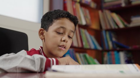 Enjoying reading school books, Arab Saudi Gulf students in the school library, doing homework, education in the Kingdom of Saudi Arabia.