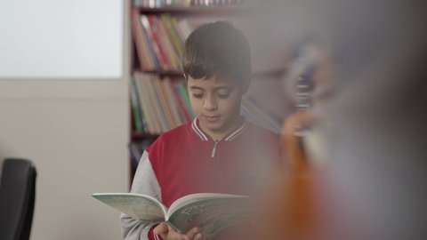 تأدية الواجبات المدرسية، طلاب عربيين سعوديين خليجيين في المكتبة المدرسية، الاستمتاع بقراءة الكتب المدرسية، التعليم في المملكة العربية السعودية