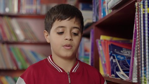 Performing school assignments, two Arab Saudi Gulf students in the school library, enjoying reading school books, education in the Kingdom of Saudi Arabia.