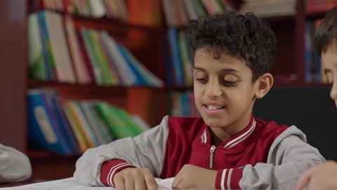 Saudi Arabian Gulf Arab students in the school library, enjoying reading textbooks, doing homework, education in the Kingdom of Saudi Arabia.