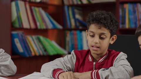 مدارس المملكة المبتكره, طلاب عرب سعوديون خليجيون يجلسون في المكتبة المدرسية،  مفهوم التعليم الذاتي, الاستمتاع بقراءة الكتب، بيئه مدرسيه تعليميه متطوره, مدارس أكاديميه في المملكة العربية السعودية