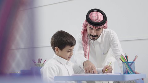 المشاركة الفعالة للطلاب مع المدرسين، معلم عربي خليجي سعودي يرتدي الثوب التقليدي والشماغ يقوم بمناقشة الدروس مع طلابه، جودة التعليم في السعودية، التربية والتعليم بالمناهج المقررة للتلاميذ، حوارات ودية بين الاستاذ والطلاب