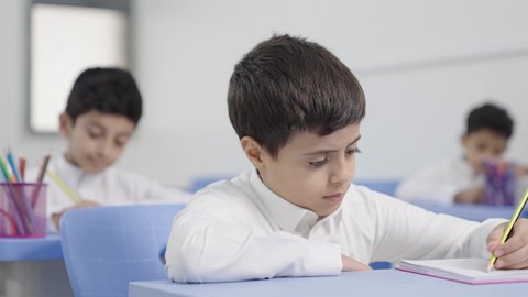 Preparation for the new school year, completing homework, education in Saudi Arabia, back to school, a group of Arab Gulf Saudi students sitting in their seats and doing their homework.