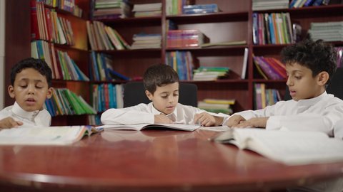 قضاء وقت ممتع ، مجموعة من طلاب عربية سعودية خليجية في المكتبة المدرسية، الاستمتاع بقراءة الكتب المدرسية، تأدية الواجبات المدرسية، التعليم في المملكة العربية السعودية