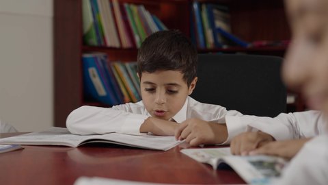 الاستمتاع بقراءة الكتب المدرسية، مجموعة من طلاب عربية سعودية خليجية في المكتبة المدرسية،  تأدية الواجبات المدرسية، التعليم في المملكة العربية السعودية