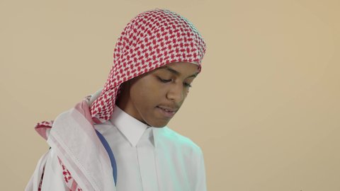 الاهتمام بتصفح الكتب المفيدة، مفهوم الاجتهاد والتفوق, الاستعداد للعام الدراسي الجديد، مراجعة الدروس اليومية, تحضير الدروس للوصول إلى النجاح, بورتريه لشاب عربي خليجي سعودي يرتدي الثوب التقليدي و شماغ و حقيبة ظهر يقوم بقراءة كتاب, تطوير المناهج التعليمية في السعودية, خلفية بيج