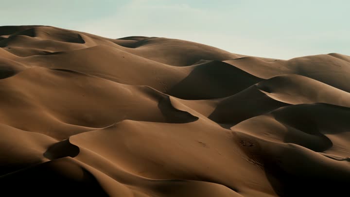 Landscape and soft golden sand in the desert, sand formations and formations in deserts, harsh and dry weather in arid lands, soft golden dunes and natural terrain in the United Arab Emirates, nature background