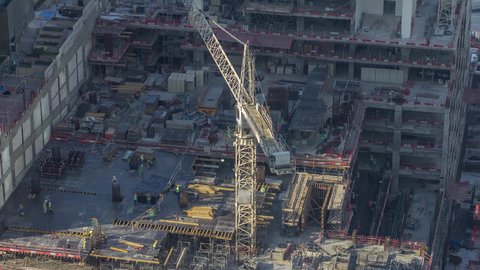 موقع بناء مزدحم بالآلات والمعدات الثقيله والرافعات والسقالات العالية, اعمال البناء وصب الخرسانات ووضع الأساسات, تنفيذ مخطط الإعمار وتشكيل الهيكل المعدني, مفهوم الهندسة الانشائية والمعمارية، مبنى قيد الانشاء في الامارات العربية المتحدة