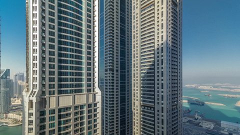 Towers and skyscrapers in the UAE, marine transportation in Dubai Marina, sophisticated architecture of commercial and residential facilities, luxury yacht marina in Marina Mall, famous tourist attractions