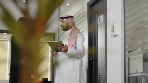 تطوير خطة وآلية العمل، التحقق والتدقيق في العروض المالية، كتابة وتسجيل البيانات والملاحظات، إنجاز الأعمال المكتبية، التفاهم والتعاون بين الزملاء لتحقيق الاهداف، رجل عربي خليجي سعودي يرتدي الزي التقليدي و الشماغ يقوم بشرح المهام لزميلته داخل الشركة