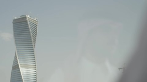 معالم الرياض السياحية، النمو والتطور العمراني، انعكاس زجاجي لرجل عربى خليجي سعودي يرتدي الشماغ ينظر من نافذة المكتب على برج المجدول في مدينة الرياض ، الفنون الهندسية المعمارية لناطحات السحاب في المملكة العربية السعودية، المباني والأبراج التجارية المشهورة